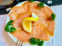 a plate of fish with a lemon and broccoli on it at Pension Karina Schwerin in Schwerin