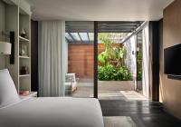 a bedroom with a white bed and a sliding glass door at Rosewood Phuket in Patong Beach