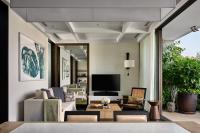 a living room with a couch and a tv at Rosewood Phuket in Patong Beach
