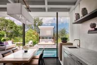 a kitchen with a swimming pool and a dining room at Rosewood Phuket in Patong Beach
