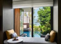 a bedroom with a large window with a view of a pool at Rosewood Phuket in Patong Beach