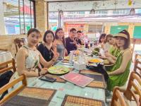 een groep mensen die aan een tafel in een restaurant zitten bij Baan Ketkeaw Guest House 2 in Patong Beach