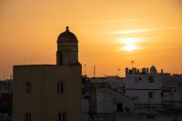 a silhouette of a building with the sunset in the background at Hotel de Francia y París in Cádiz