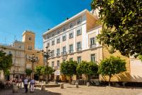 a large building with people walking in front of it at Hotel de Francia y París in Cádiz