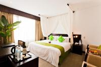 a hotel room with a large bed with green pillows at The Loft Seaside Suites in Jinshan