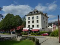 a white building with a horse statue in front of it at Hotel du Parc in Diekirch