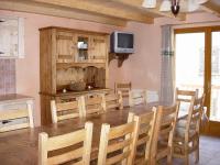 a dining room with a table and chairs and a tv at BOROT2 in Lanslebourg-Mont-Cenis