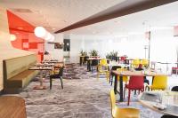 Un restaurante con mesas y sillas en una sala. en Novotel Wrocław City, en Wroclaw