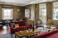 a living room with a red couch and chairs at The Cliffside Inn in Newport