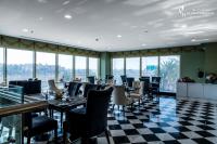 Un restaurante con suelo de cuadros y mesas y sillas. en LeChateau Boutique Hotel, en Yeda