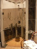 a bathroom with a shower with the word mom on the wall at Hotel Le Mandelberg in Mittelwihr