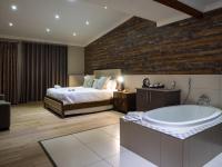 a bedroom with a bed and a bath tub at Hotel @ Secunda in Secunda