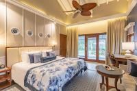 a bedroom with a king sized bed and a desk at Taj Holiday Village Resort & Spa, Goa in Candolim