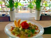 阿西尼Hotel Coucoue Lodge的盘子上摆着餐桌的食物