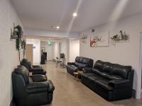una sala de espera con sillones y sillas de cuero negro en Quokka Backpackers Hostel Perth - note - Valid passport required to check in, en Perth