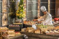 a chef preparing food at a buffet in a restaurant at Four Seasons Hotel Hong Kong in Hong Kong