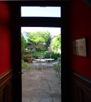 a door leading to a patio with a table and chairs at Le Magnolia in La Rochefoucauld