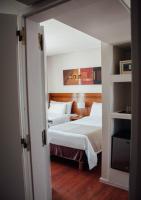 a bedroom with two beds and a television in it at Herradura Hotel Suites in Neuquén