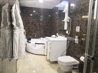 a bathroom with a white toilet and a sink at Maximus Hotel Byblos in Jbeil