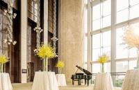 a lobby with tables and a piano in a building at Four Seasons Hotel Hong Kong in Hong Kong