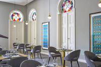 ein Esszimmer mit Tischen, Stühlen und Buntglasfenstern in der Unterkunft Central Monchique Hotel - Villa Termal Spa Resort - by Unlock Hotels in Monchique