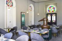 ein Esszimmer mit Tischen, Stühlen und Buntglasfenstern in der Unterkunft Central Monchique Hotel - Villa Termal Spa Resort - by Unlock Hotels in Monchique