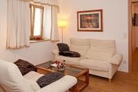 a living room with two white chairs and a table at Serviced Apartement Sonnleitner in Furth