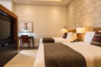 a hotel room with two beds and a desk at Marsella 45 in Hermosillo