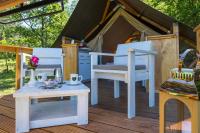 a porch with white chairs and a table and a tent at Kamp Romantik - glamping in Labin