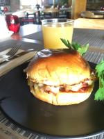 Un sándwich en un plato negro con un vaso de jugo de naranja. en Quality Inn Carriage House, en Wagga Wagga