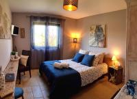 a bedroom with a bed with blue pillows at La Villa Esterel &amp; SPA in Village-Neuf
