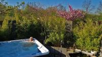 a person in a bath tub in a garden at La Villa Esterel &amp; SPA in Village-Neuf