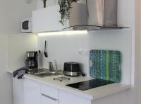 a white kitchen with a sink and a stove at Clos Chantegrive in Saint-Médard-en-Jalles