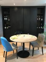 a table and chairs in a room with wine bottles at The Originals City, Hôtel Hélios, Roanne Nord (Inter-Hotel) in Mably