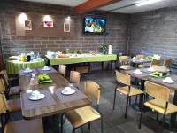 een eetkamer met tafels en stoelen en een tv bij Pousada Santo Antônio in Bento Gonçalves