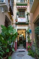 an entrance to a building with plants and a sign at Pensión San Benito Abad in Seville