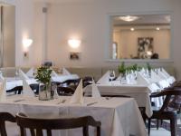 una fila de mesas con manteles blancos. en Hotel Sandwirth, en Klagenfurt