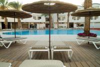 2 Stühle und Sonnenschirme neben einem Pool in der Unterkunft Leonardo Privilege Eilat Hotel - All inclusive in Eilat