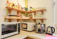 a kitchen counter with a microwave and a toaster oven at T-Life Hostel in Longjing