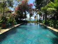 a swimming pool in a resort with palm trees at Full Moon Beach Resort in Mui Ne