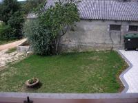 a small yard with a tree and a wall at Agroturism Stara Štala in Borut