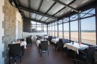 a dining room with tables and chairs and the beach at Antinéa in Saint Malo