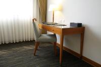 a desk with a lamp and a chair in a room at Fushin Hotel Taichung in Taichung