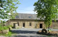 an old brick building with a tree in front of it at LA COURTEILLE in Saint-Fraimbault-sur-Pisse