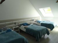 a bedroom with two beds with blue sheets and a window at LA COURTEILLE in Saint-Fraimbault-sur-Pisse
