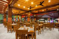 a restaurant with wooden tables and wooden chairs at Astagina Resort Villa and Spa in Legian
