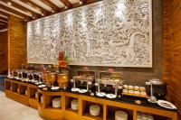 a buffet line with plates and a large painting on the wall at Astagina Resort Villa and Spa in Legian