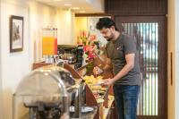 Vision Premier Hotel & Spa في هانوي: رجل يحضر الطعام في مطبخ