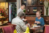 Vision Premier Hotel & Spa في هانوي: مجموعة من الناس يجلسون على طاولة في مطعم