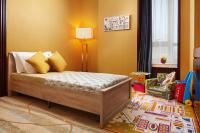 a childs bedroom with a bed and a chair at Beijing Hotel Minsk in Minsk